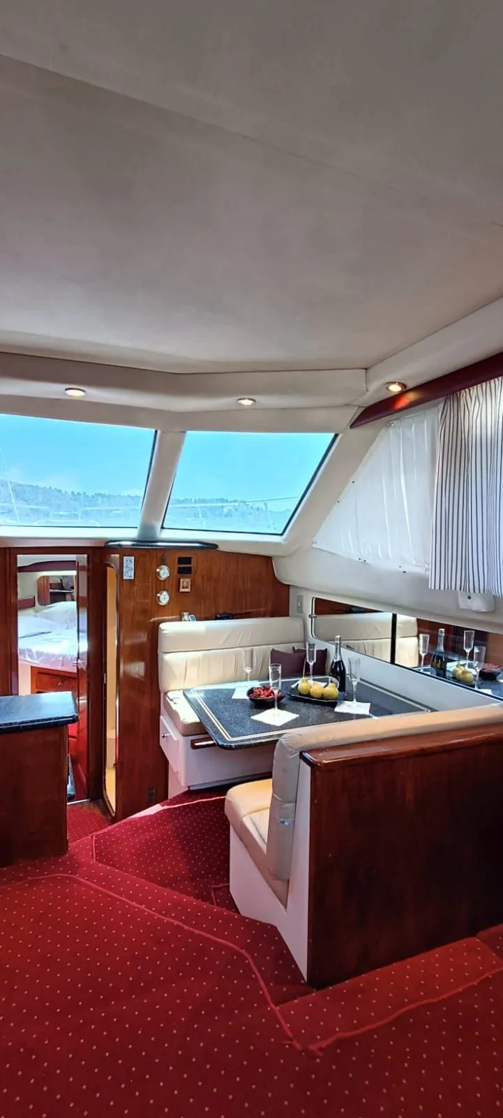 The salon dinette set with champagne and fruit, a cabin glimpsed through the open door